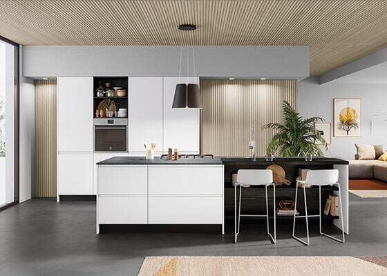 Moderna cucina bianca con isola, sgabelli da bar e una grande finestra.