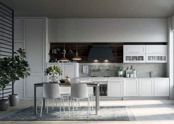 Cucina moderna con mobili bianchi, cappa scura, dettagli in legno, tavolo, sedie e piante.