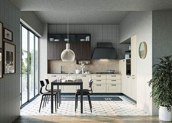 Cucina moderna con mobili color crema, tavolo e sedie scuri e una grande finestra.