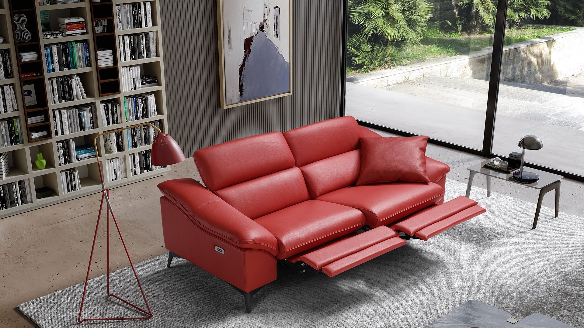 Divano reclinabile in pelle rossa in un soggiorno moderno con libreria, lampada e finestra con vista.