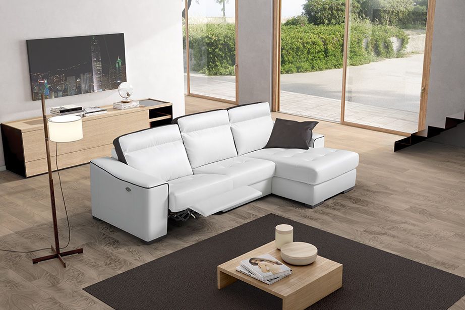 Divano componibile bianco con poltrona reclinabile in un soggiorno moderno.
