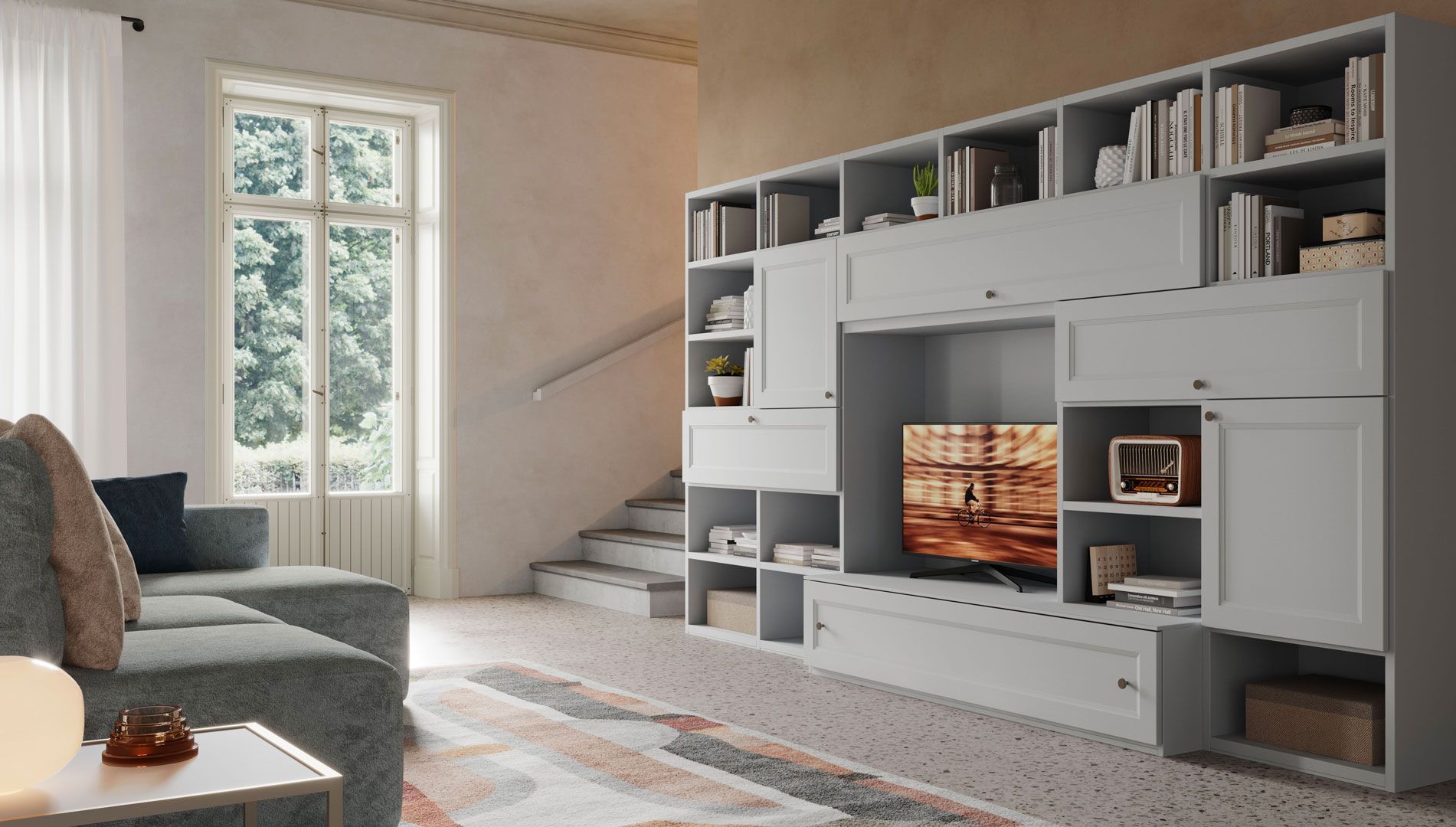Soggiorno con scaffalature grigie integrate, divano, TV, finestra, scala e tappeto.