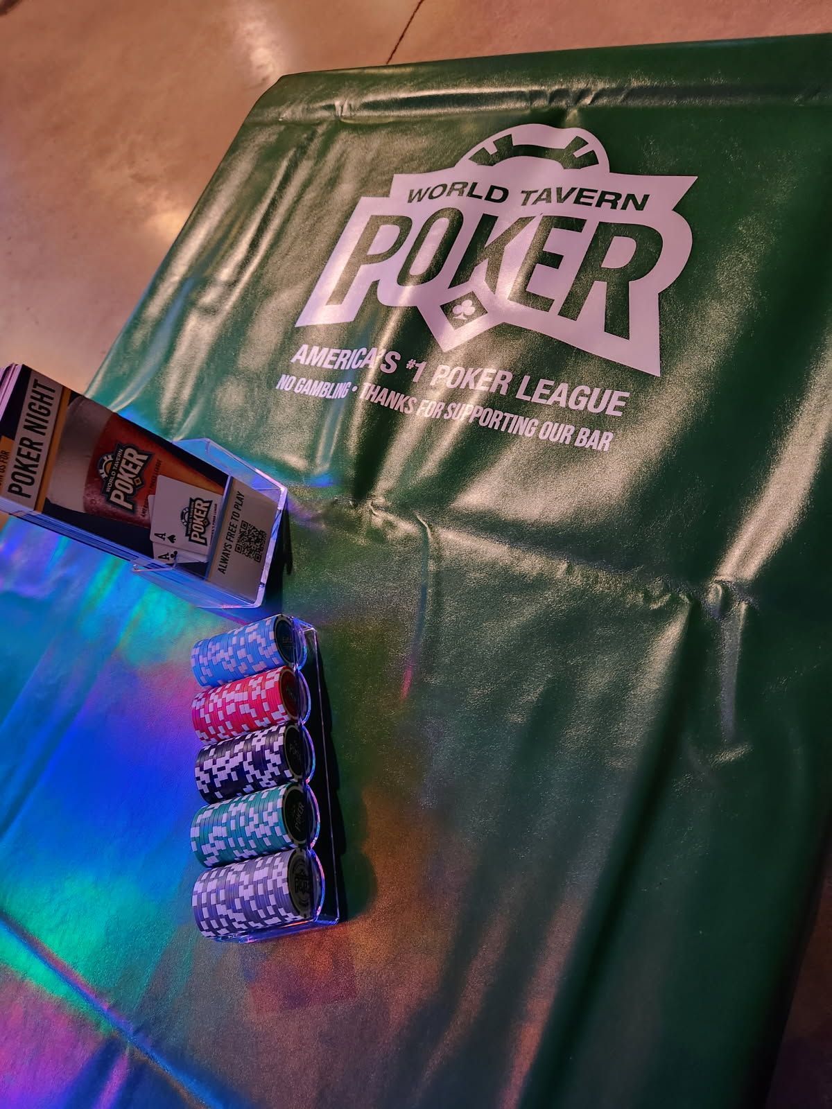 Audience at an indoor event, some looking at their phones, others watching.