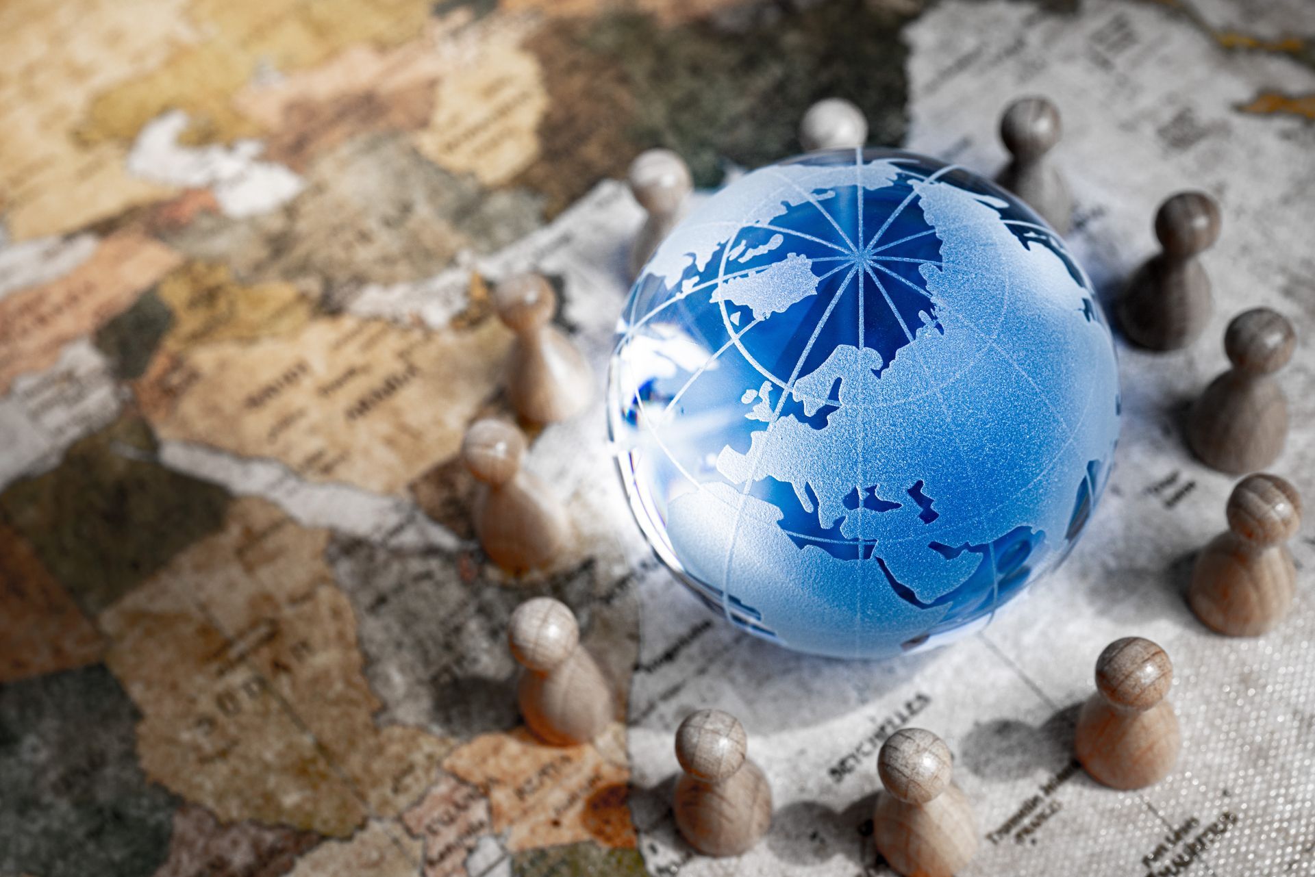 A glass globe is surrounded by wooden pieces on a map.