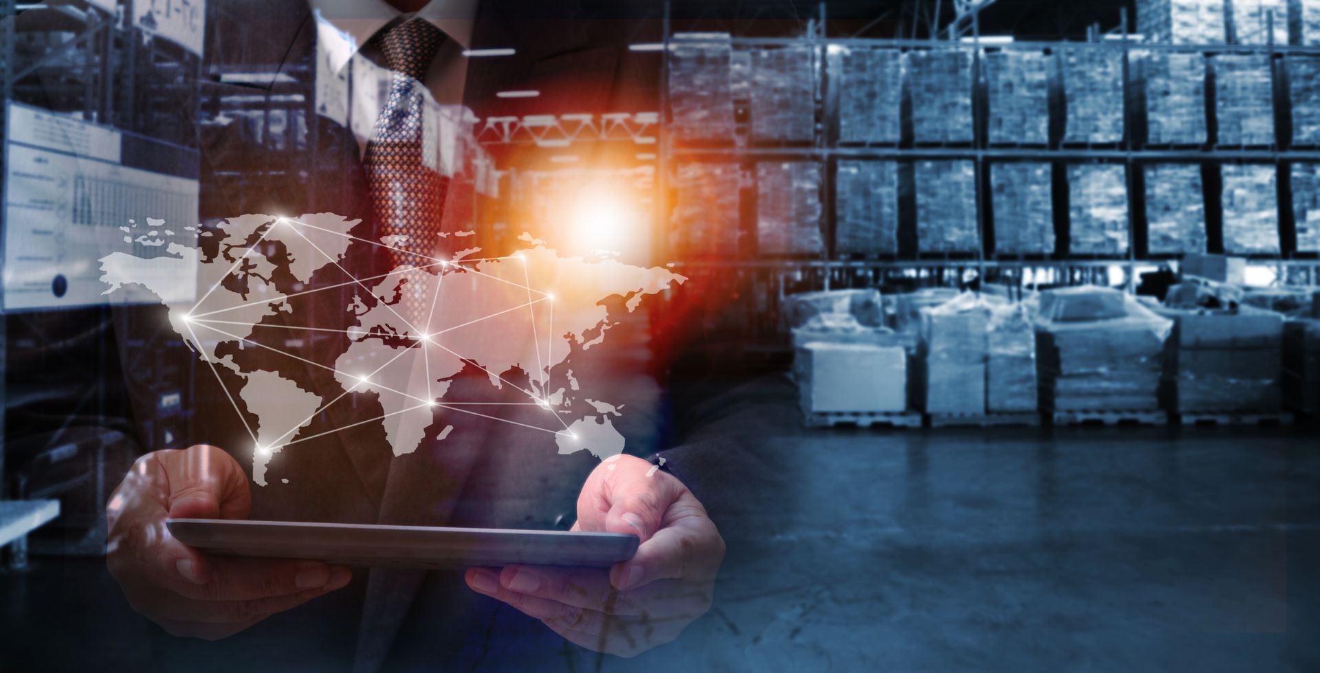 A man in a suit is holding a tablet with a map of the world on it to signify wholesale distribution success.