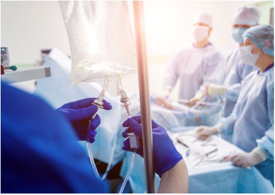 A group of surgeons are performing surgery on a patient in an operating room while wearing nitrile gloves.