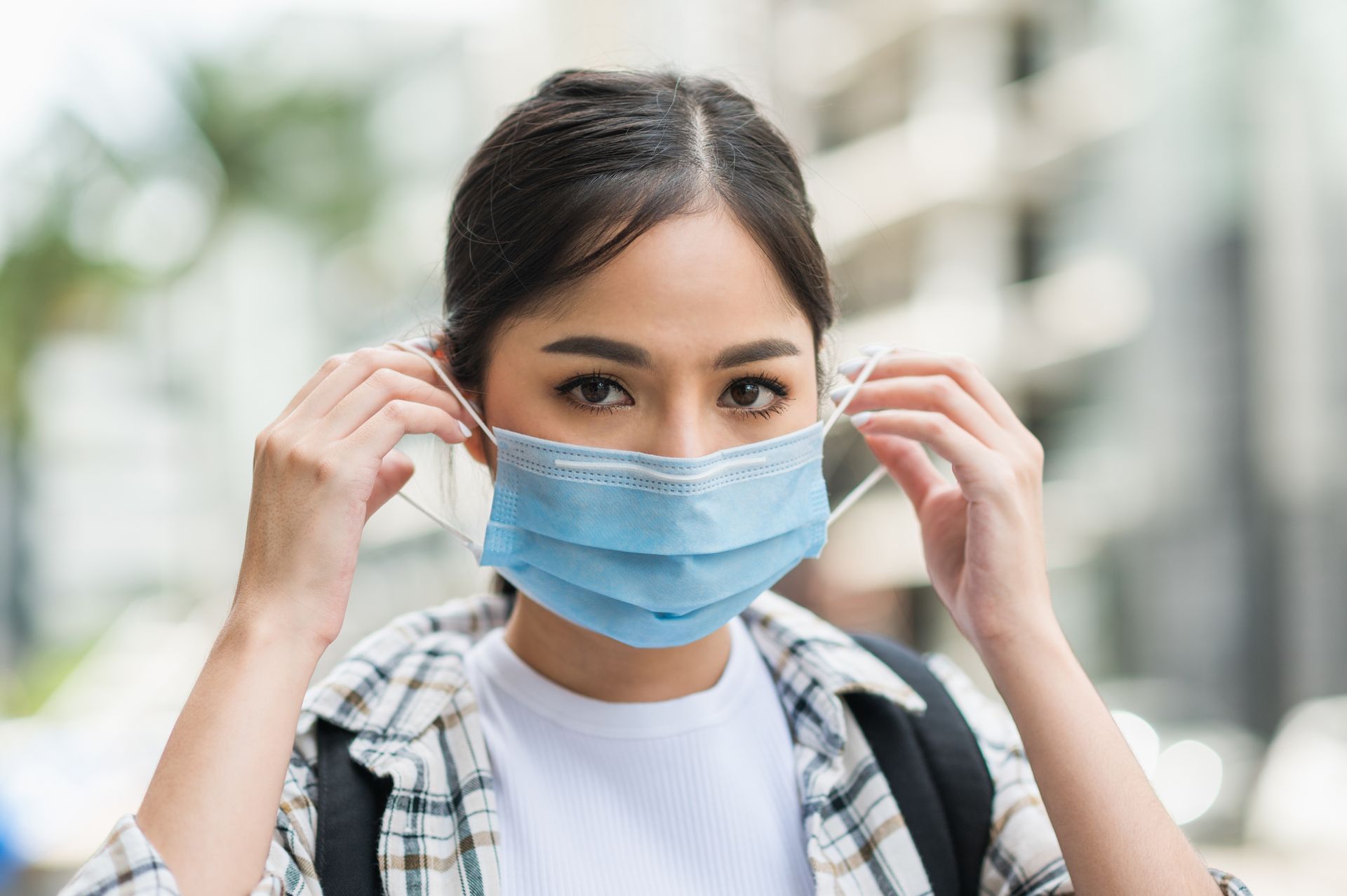 A woman is wearing a blue face mask on her face.