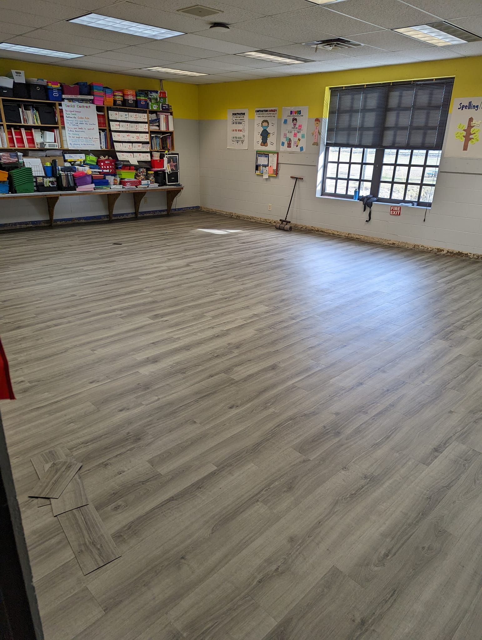 A large room with a wooden floor and a window.