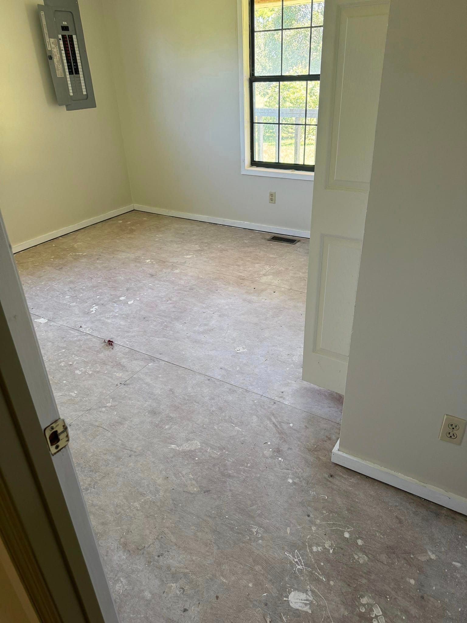 An empty room with a window and a door.