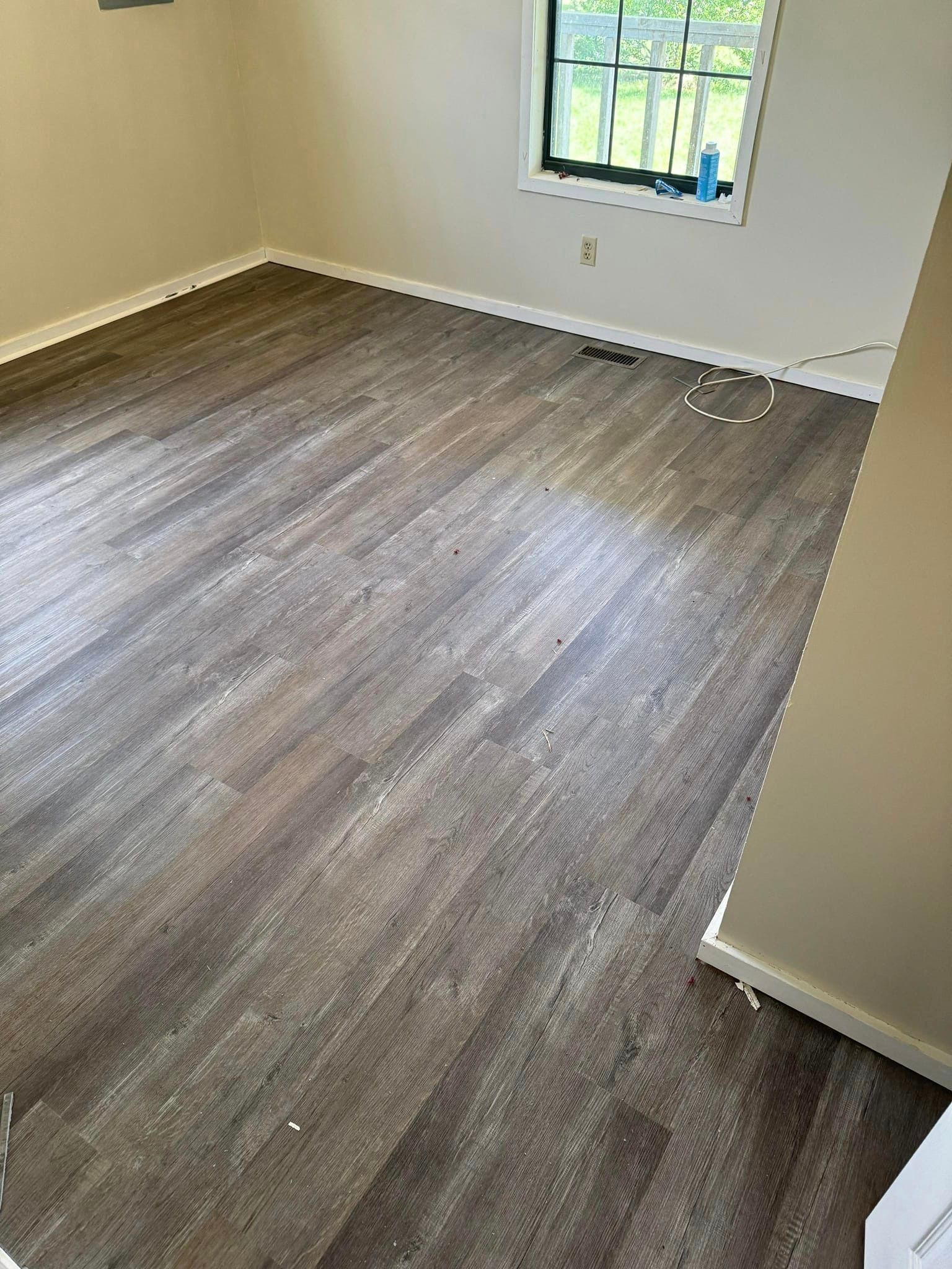 A room with a wooden floor and a window.
