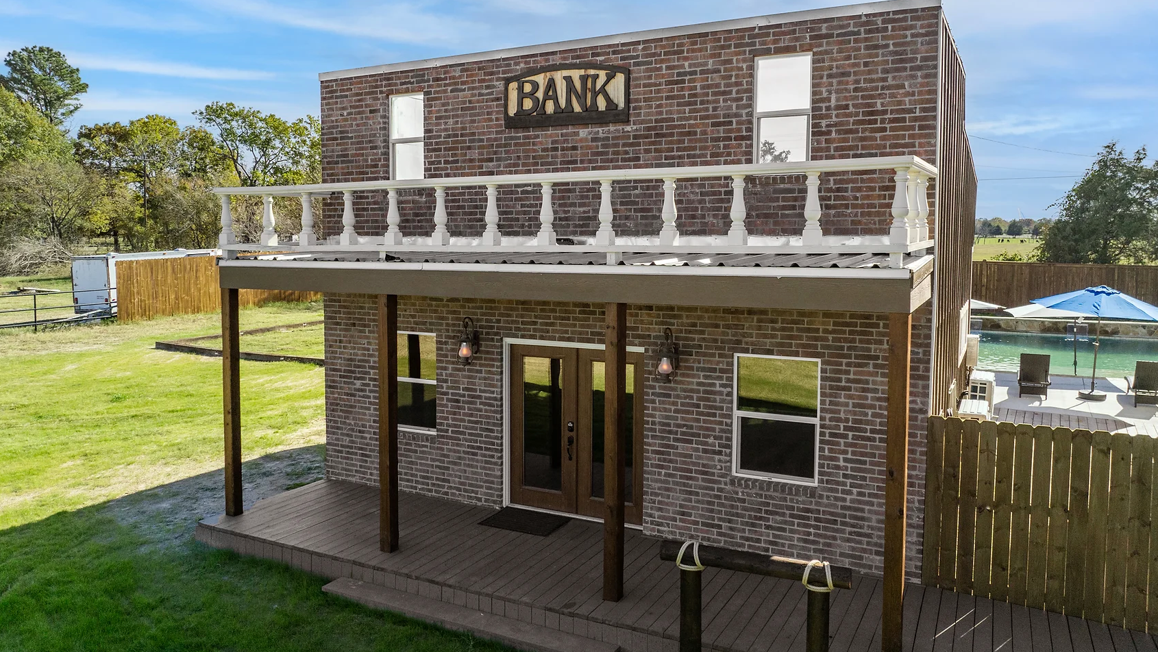 A brick building with a balcony and a sign that says bank on it.