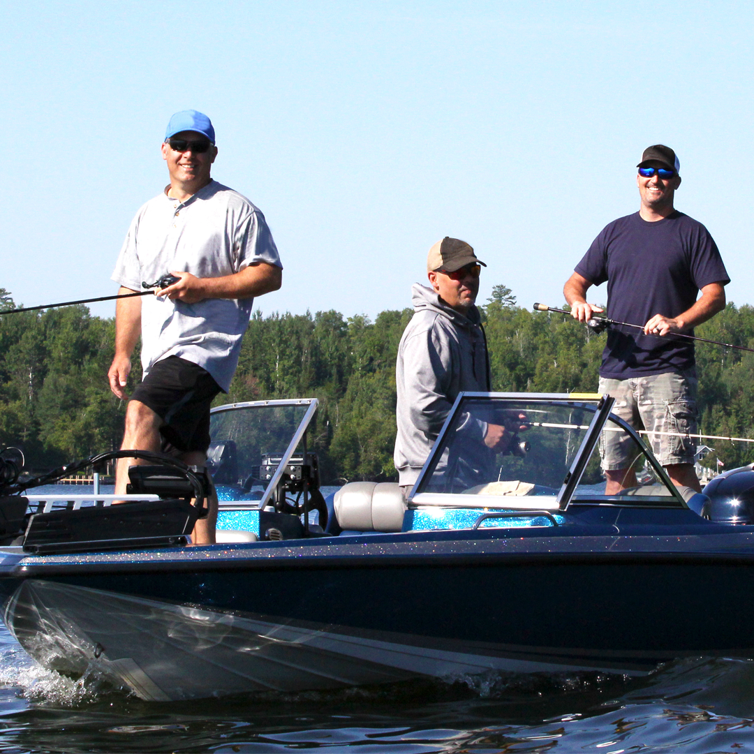 Three men are fishing in a boat on a lake