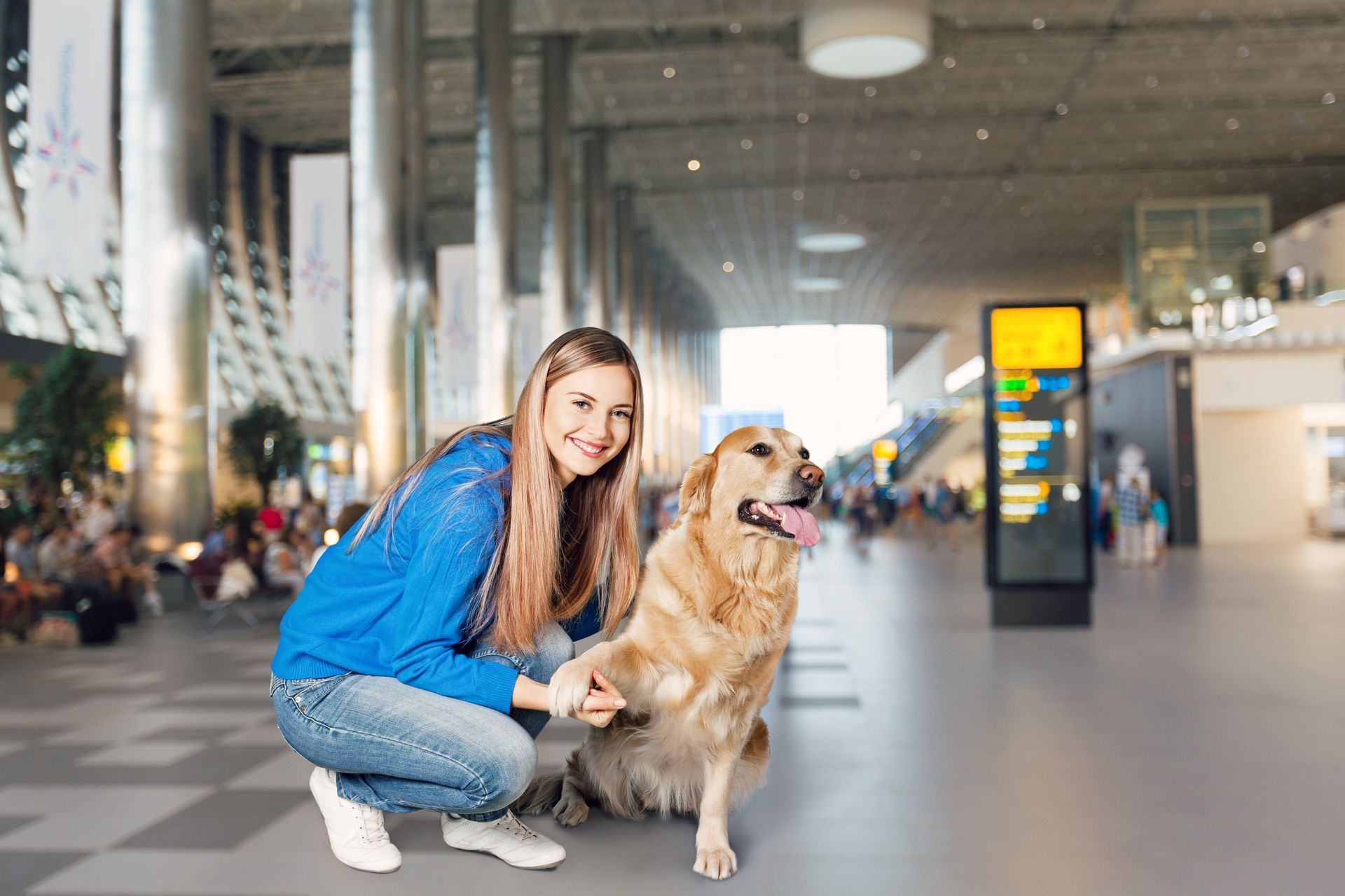 Woman and golden retriever dog at an airport