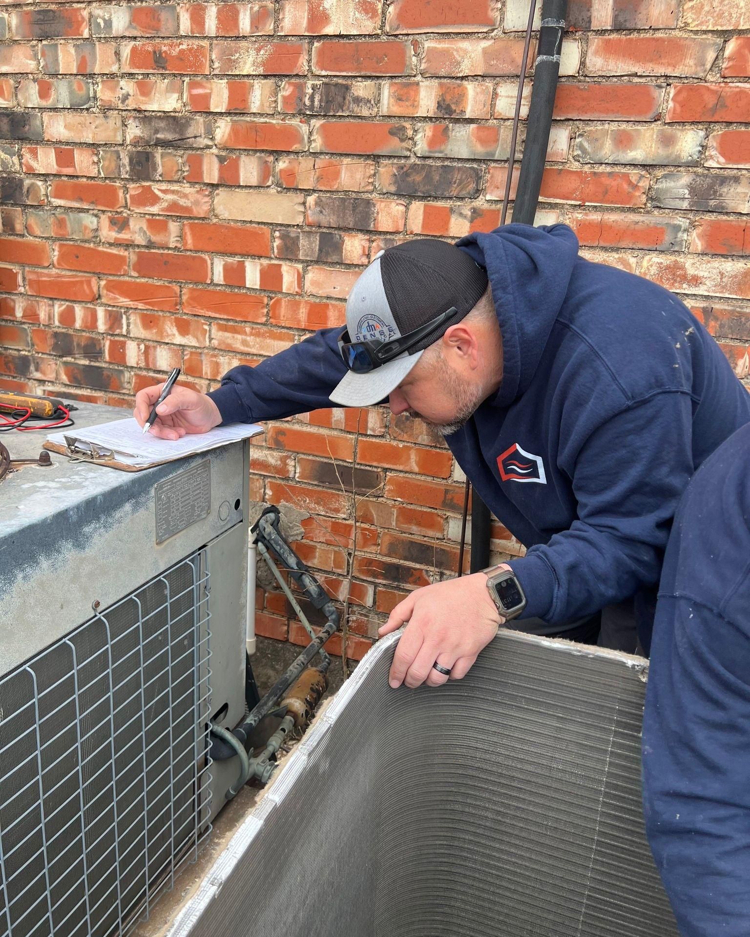 Man Inspecting The Aircon | Enid, OK | Dense Comfort Solutions