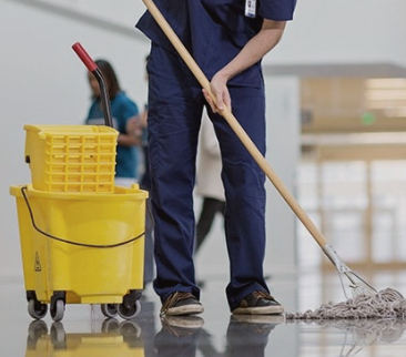 A person cleaning a floor with a mop and bucket