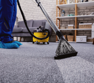 A person is using a vacuum cleaner to clean a carpet in a living room.