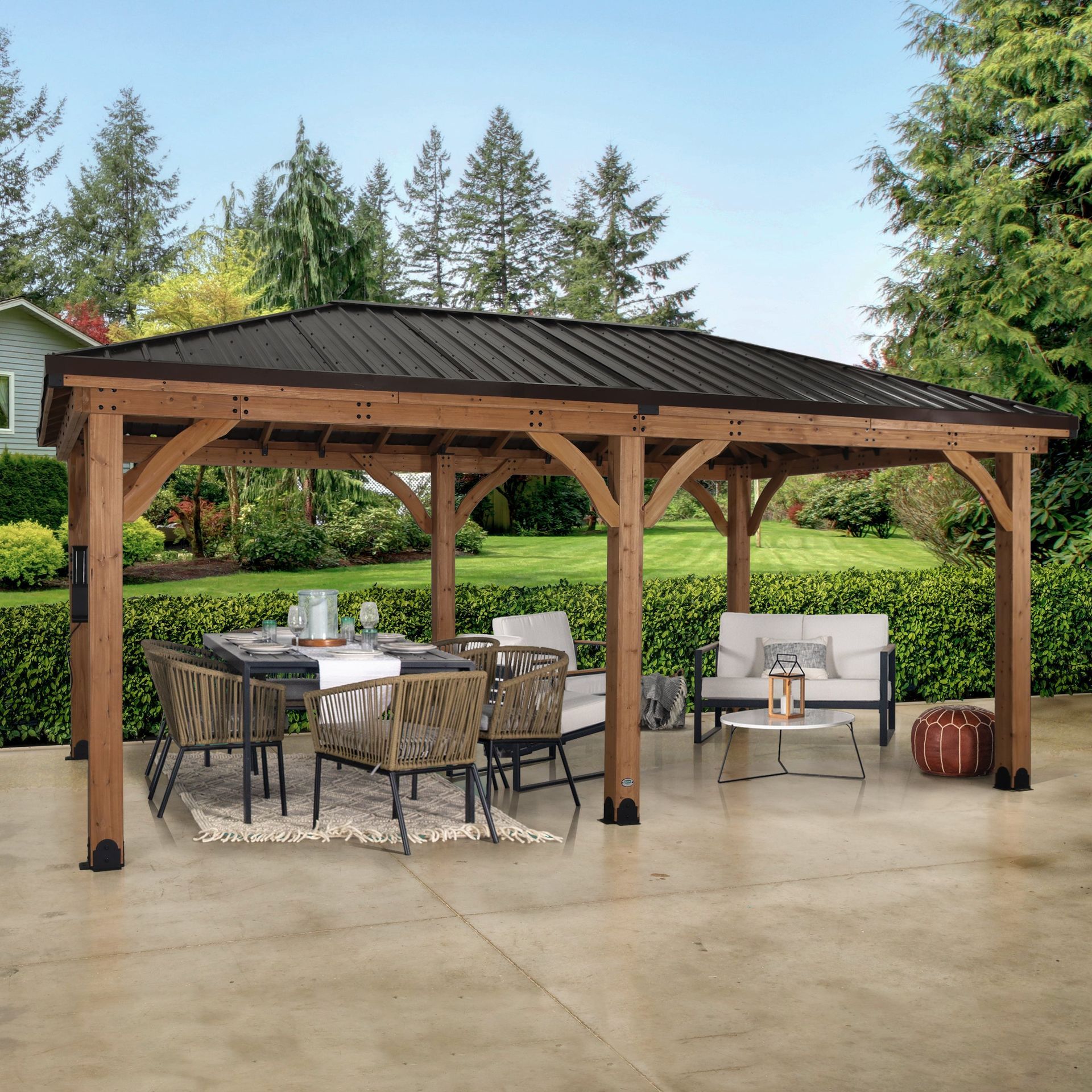 Wooden gazebo with dark metal roof over outdoor dining and seating area.
