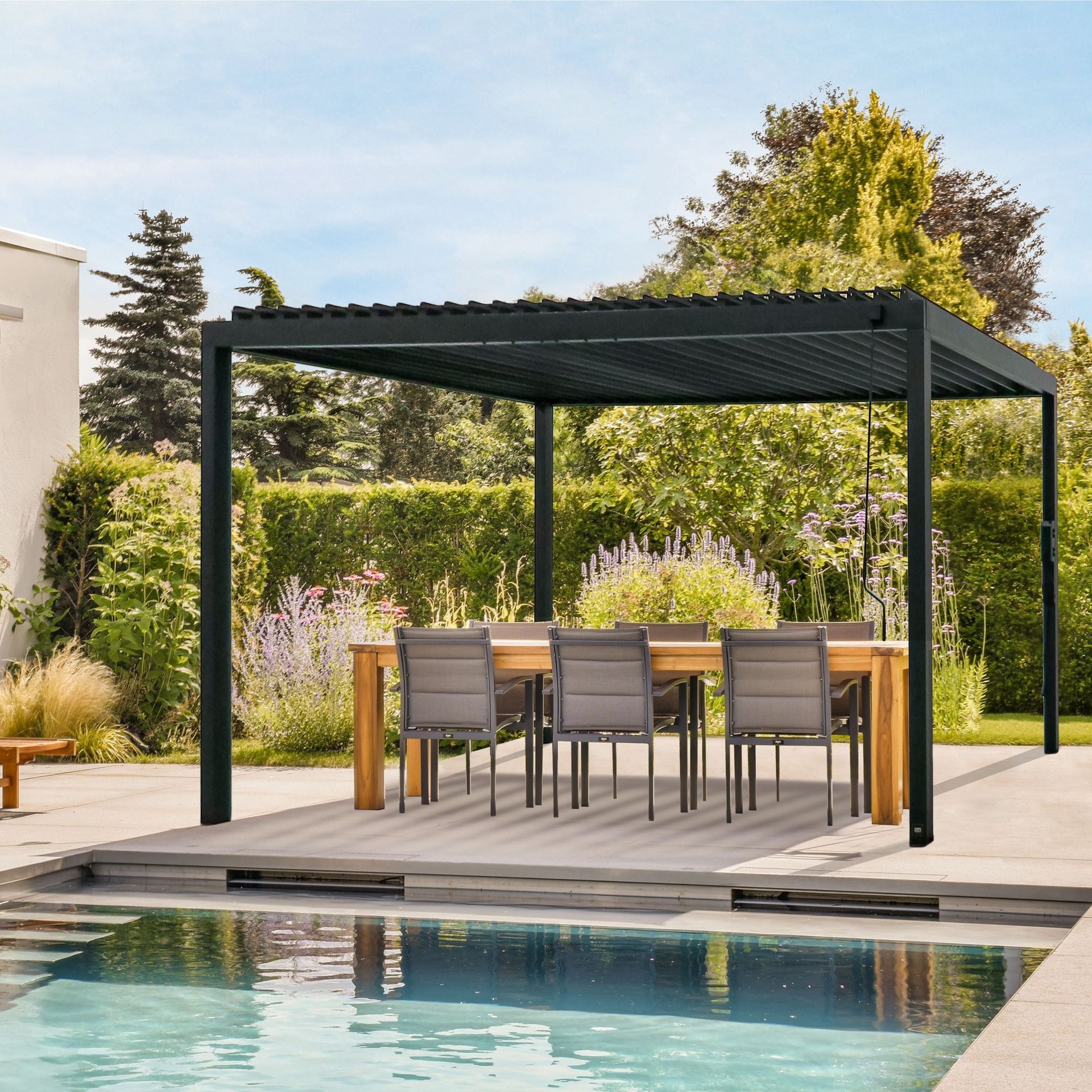 Black pergola over a wooden table and chairs by a pool in a backyard.