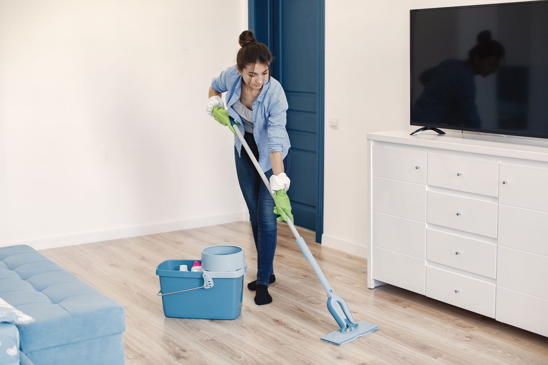 woman cleaning bedroom with mop