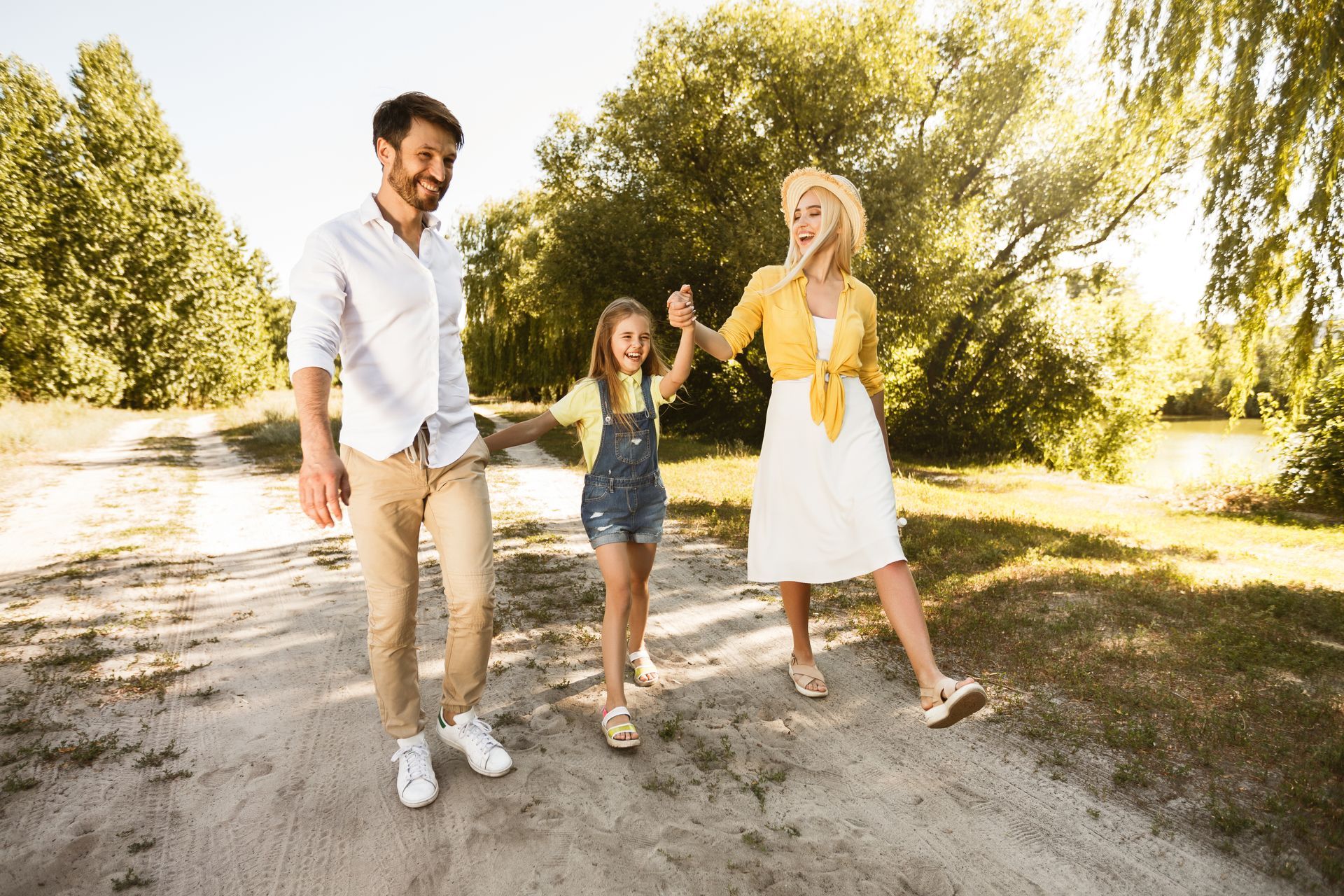 A boy is running towards an elderly couple sitting on a blanket in the grass.