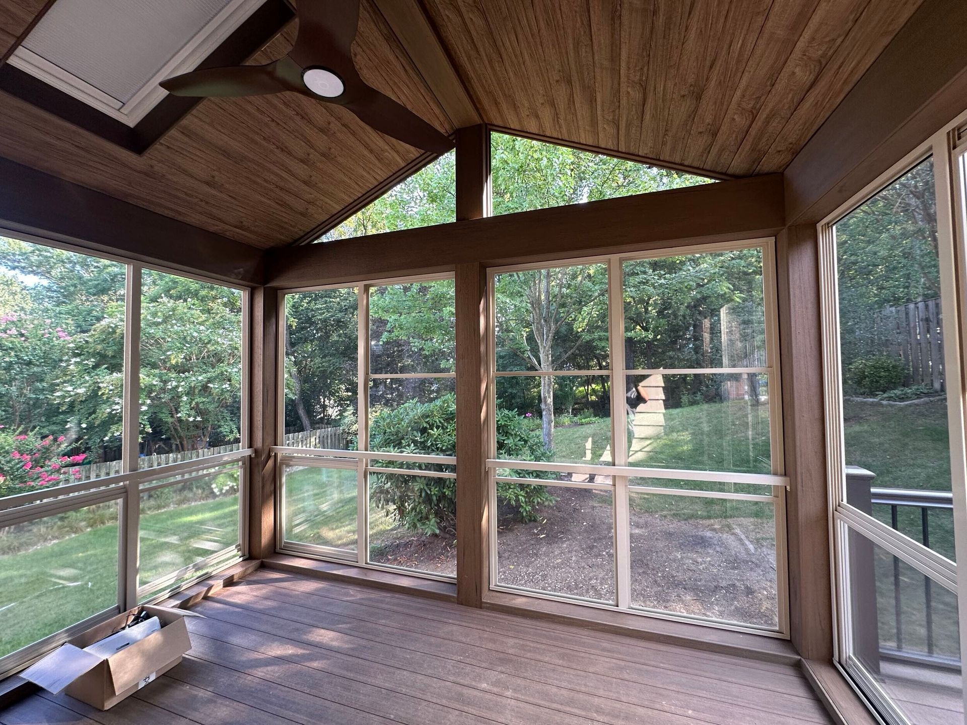 Backyard view of a house with a sunroom, patio furniture, and dusk lighting.
