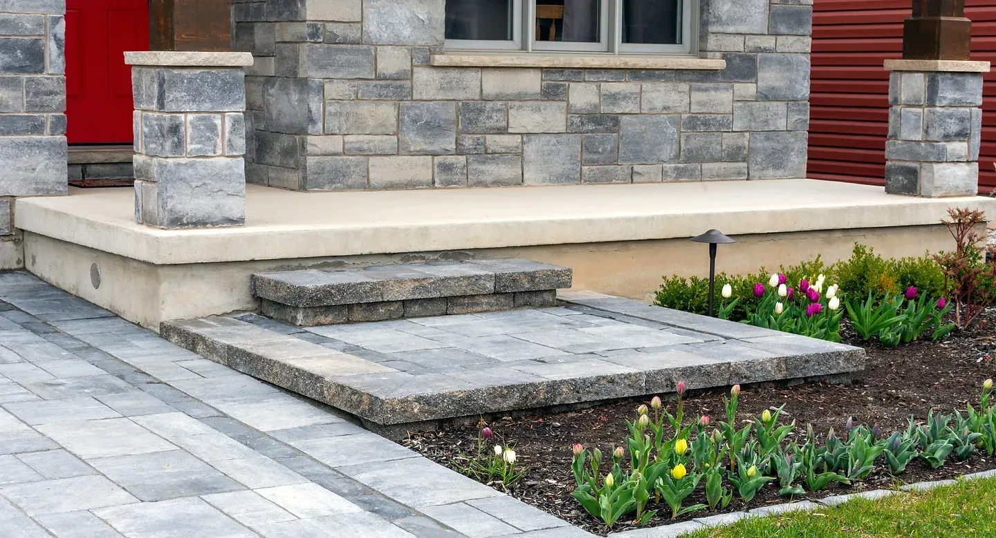 Une maison en brique avec un porche et des marches qui y mènent.