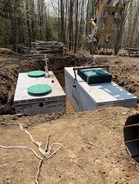 Deux fosses septiques sont en cours de construction dans un champ de terre.