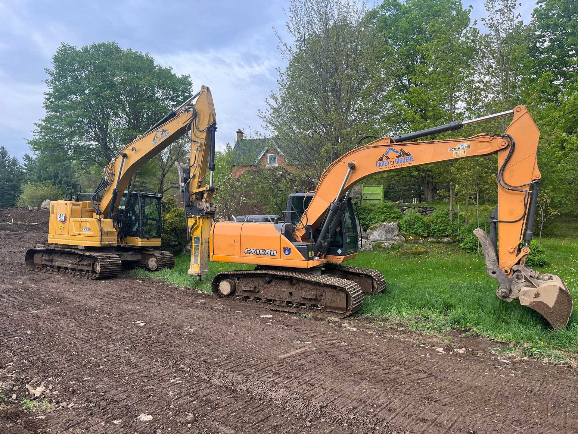 Deux excavatrices sont garées l'une à côté de l'autre dans un champ de terre.