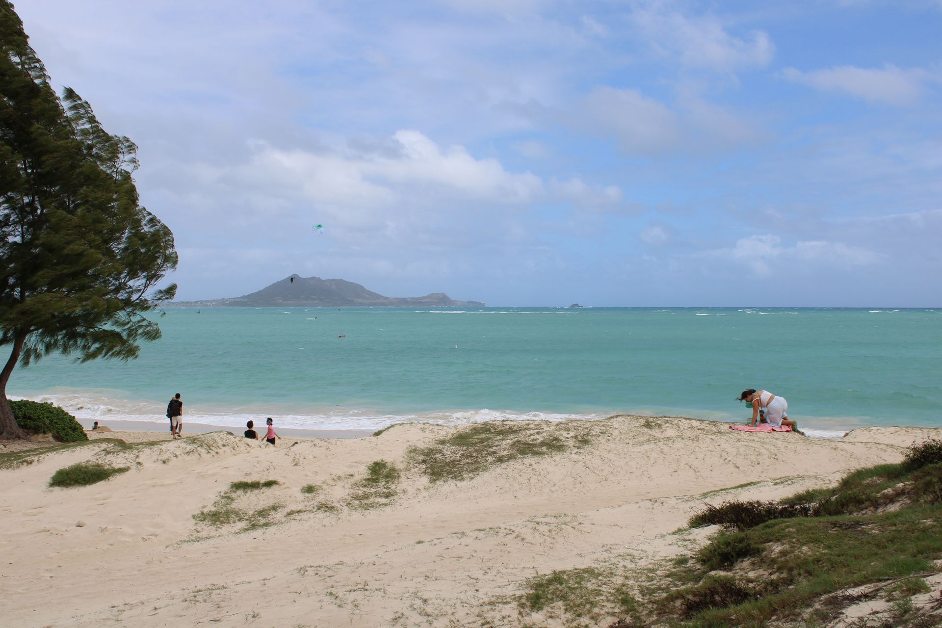 People are playing on a sandy beach near the ocean