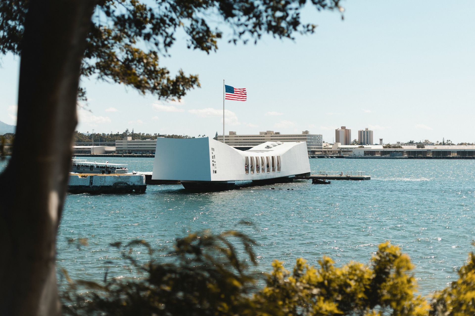 Arizona memorial on the water with American flag in the background