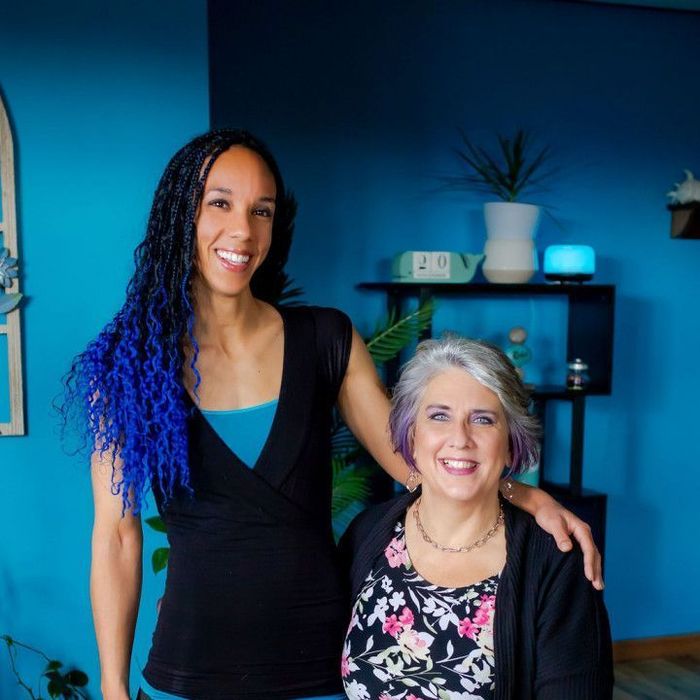 A woman with blue hair is standing next to another woman