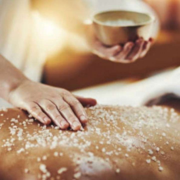 A person is getting a massage with sea salt on their back.