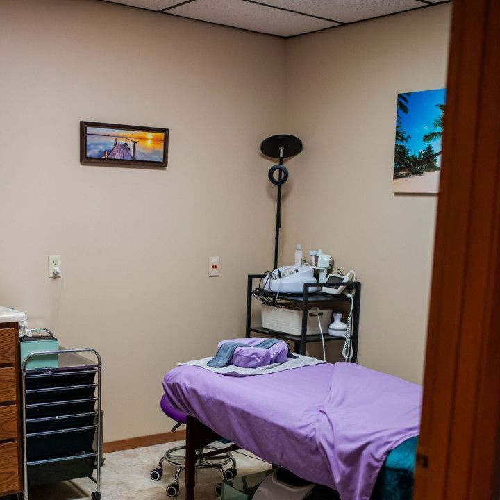 A room with a purple bed and a picture on the wall