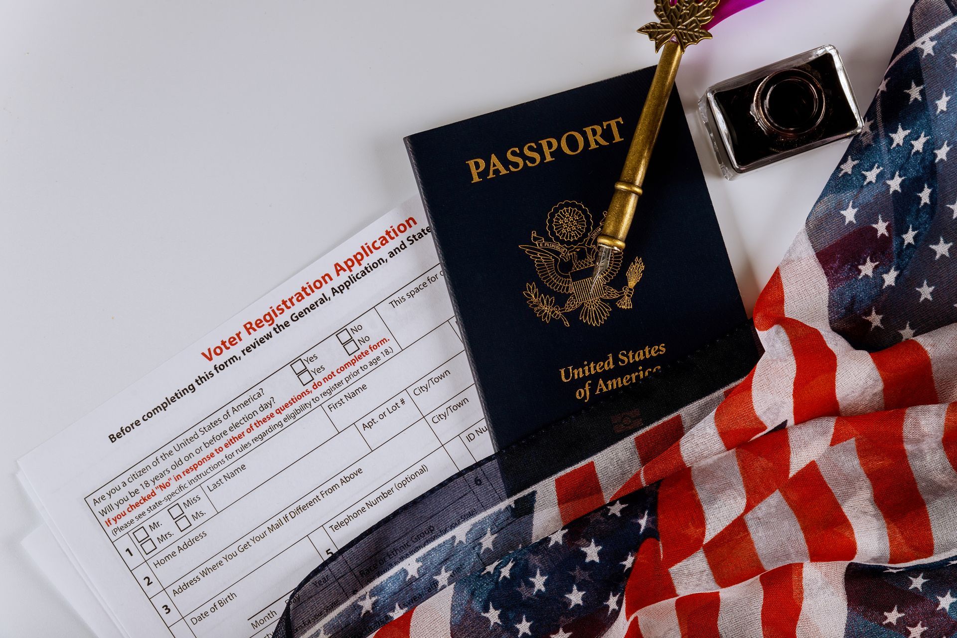 a passport , a camera , and an american flag are on a table .