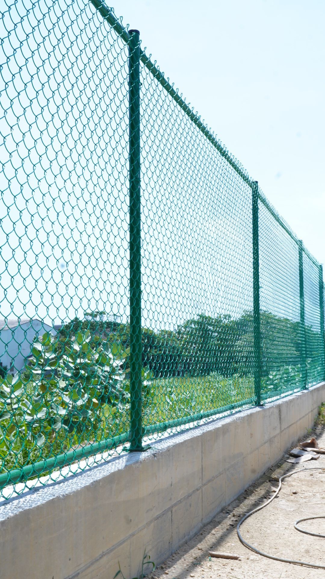 Balcón de un rascacielos con red de seguridad, con vistas a la ciudad al atardecer. Una bombilla cuelga del techo.