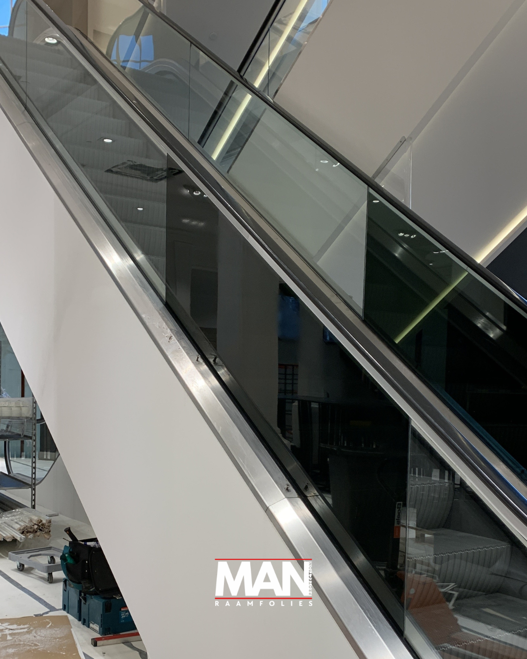 Decoratieve raamfolie op de roltrappen bij het winkelpand van H&M te Den Haag.