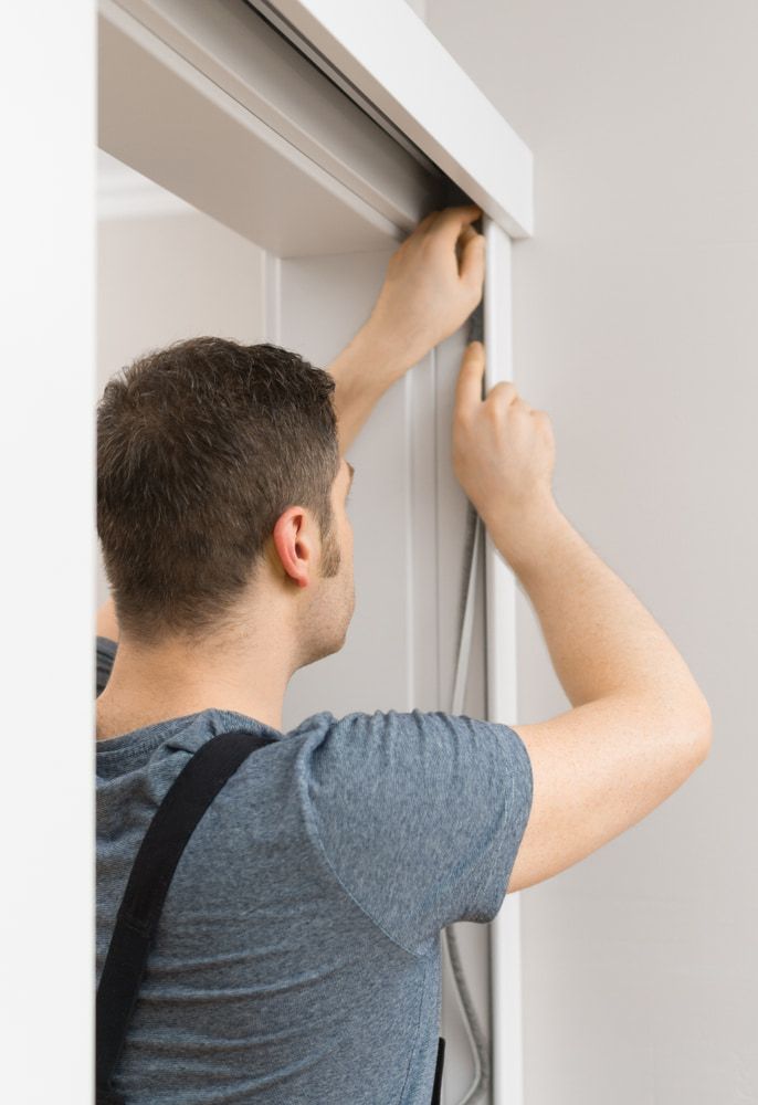 A Man Is Installing A Sliding Door In A Room — Dachboe Your Handyman in Townsville, QLD