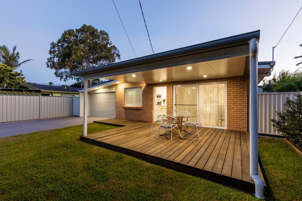 Brick Home With Wooden Deck and Seating Area — Dachboe Your Handyman In Townsville, QLD
