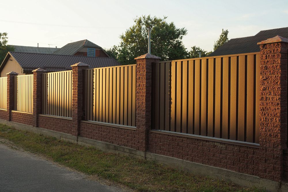 Brown Fence With Vertical Metal Slats and Brick Pillars — Dachboe Your Handyman In Ingham, QLD