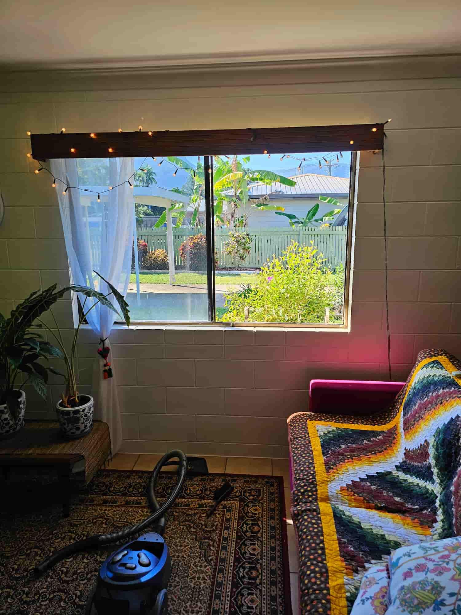 A Living Room With A Couch And A Vacuum Cleaner In Front Of A Window — Dachboe Your Handyman in Townsville, QLD