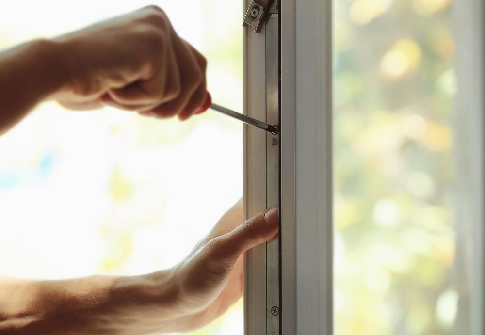 A Person Is Fixing A Window With A Screwdriver — Dachboe Your Handyman in Ayr, QLD
