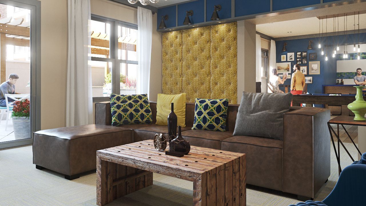 Bright modern community lounge with a brown sectional sofa, rustic wooden coffee table, and decorative cushions.