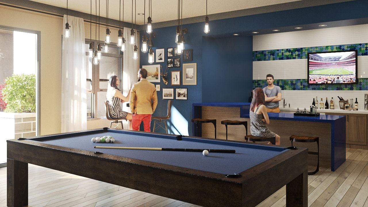 Indoor resident lounge with a pool table and bar, people socializing.