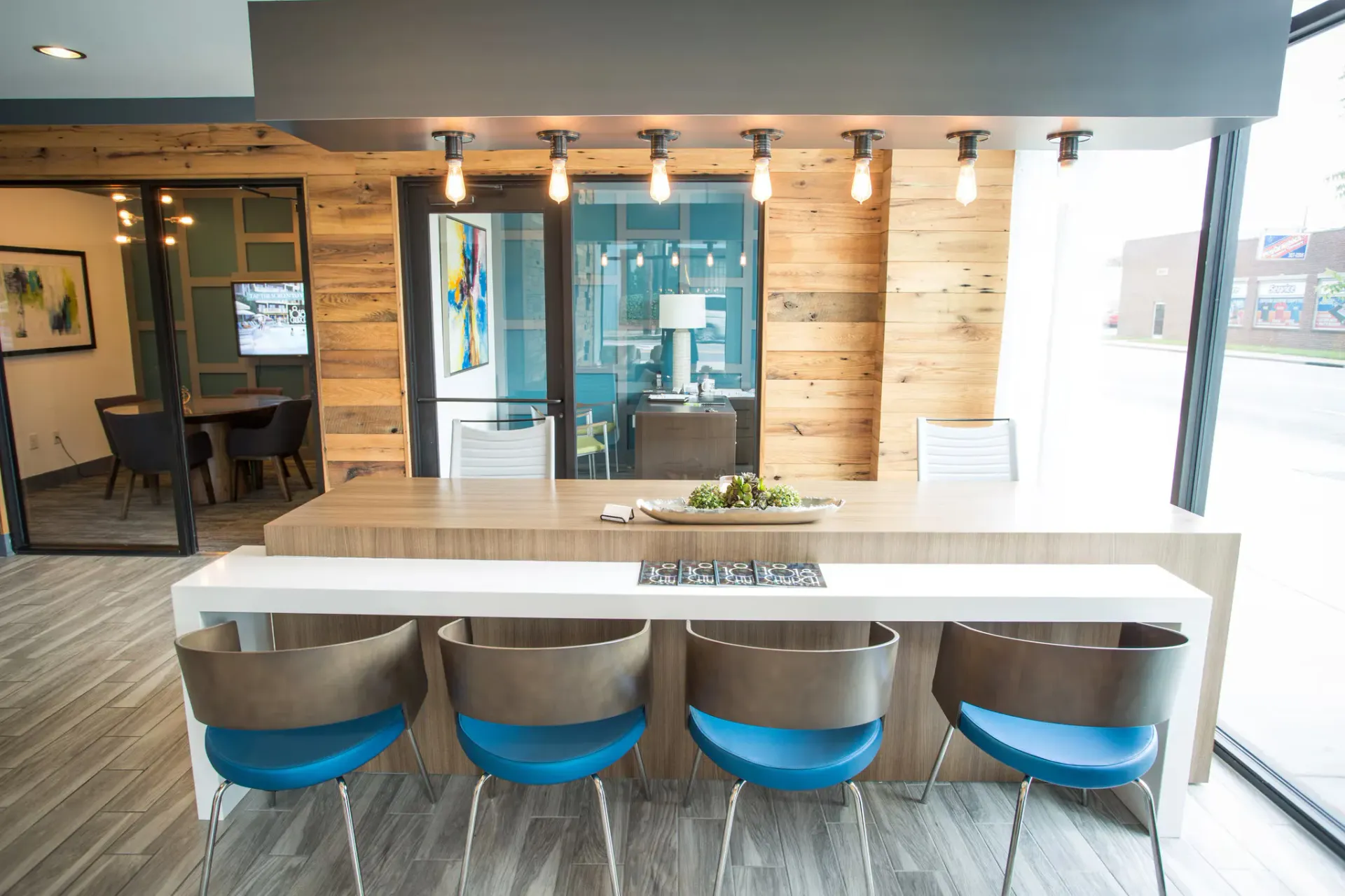 Modern community lounge with a long bar-height counter and blue stools.