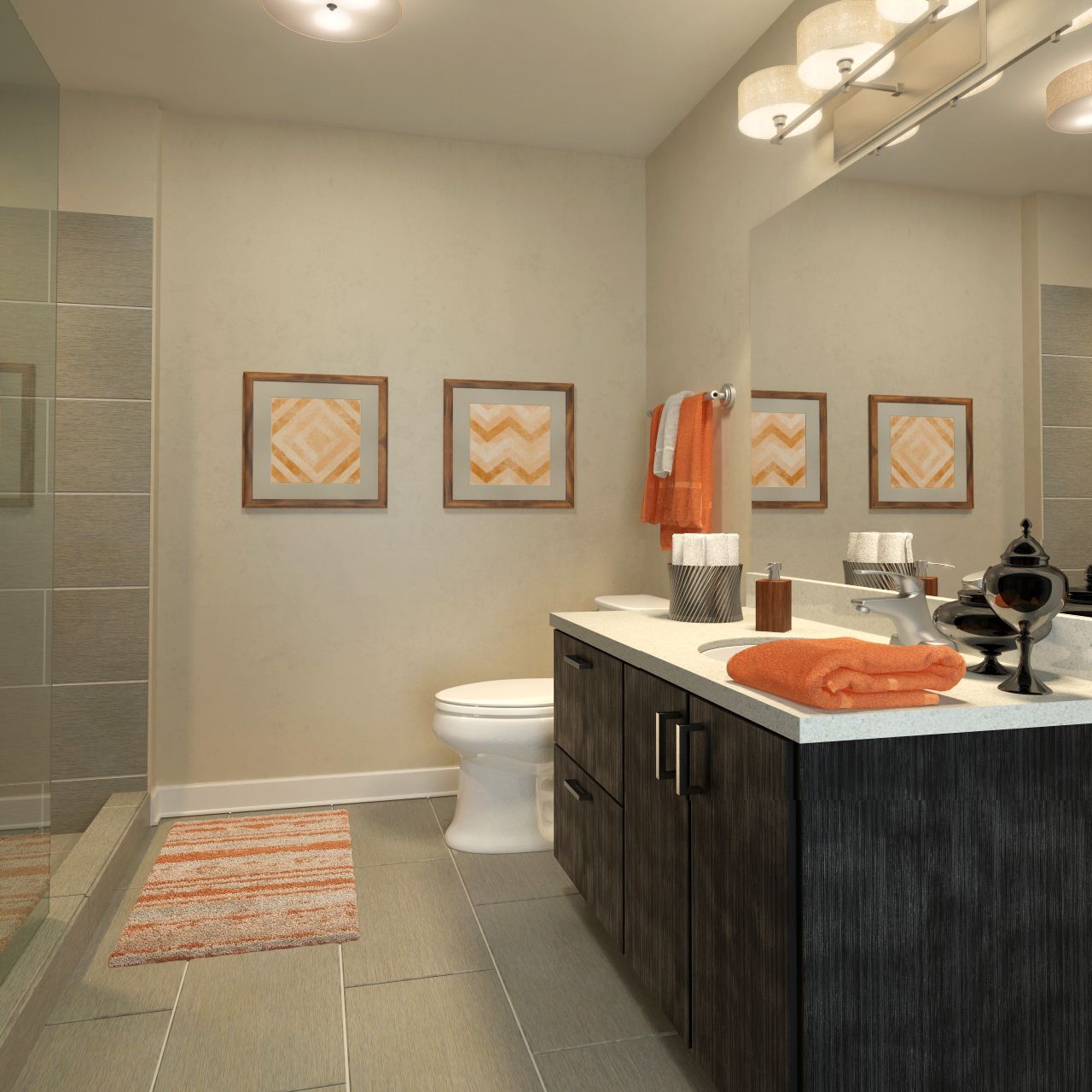 Modern apartment bathroom with vanity, sink, toilet, glass shower, and orange towels.