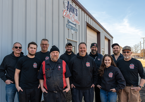 Group of auto repair shop employees posing outside building. | Arn's Auto Service