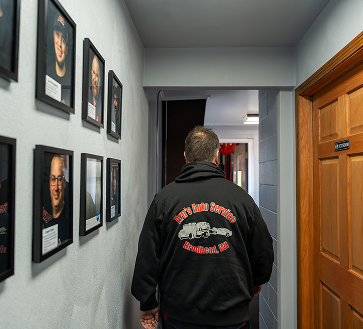 Man walking down a hallway, wearing a black sweatshirt. | Arn's Auto Service