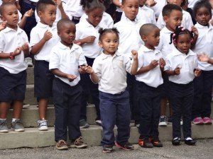 A group of children in school uniforms are standing on a set of stairs