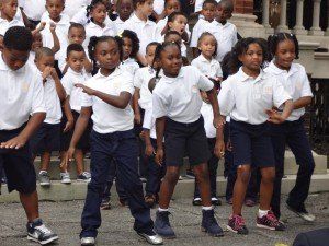 A group of children are dancing in front of a building