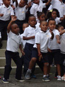A group of children in school uniforms are dancing together